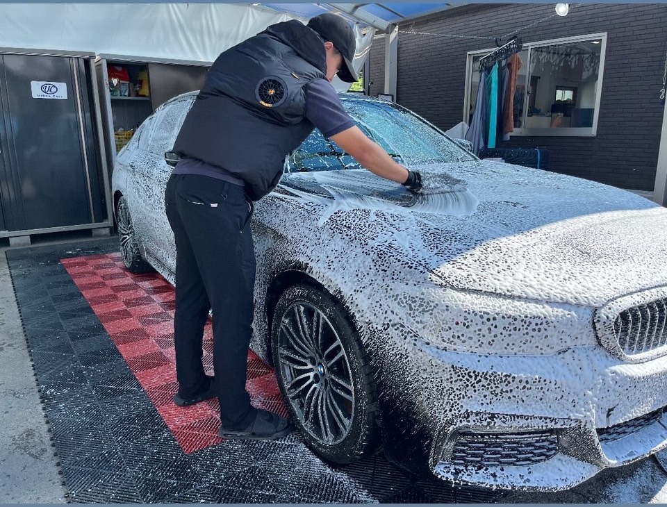 車全体を豊かな泡で包み、手洗いする施工風景